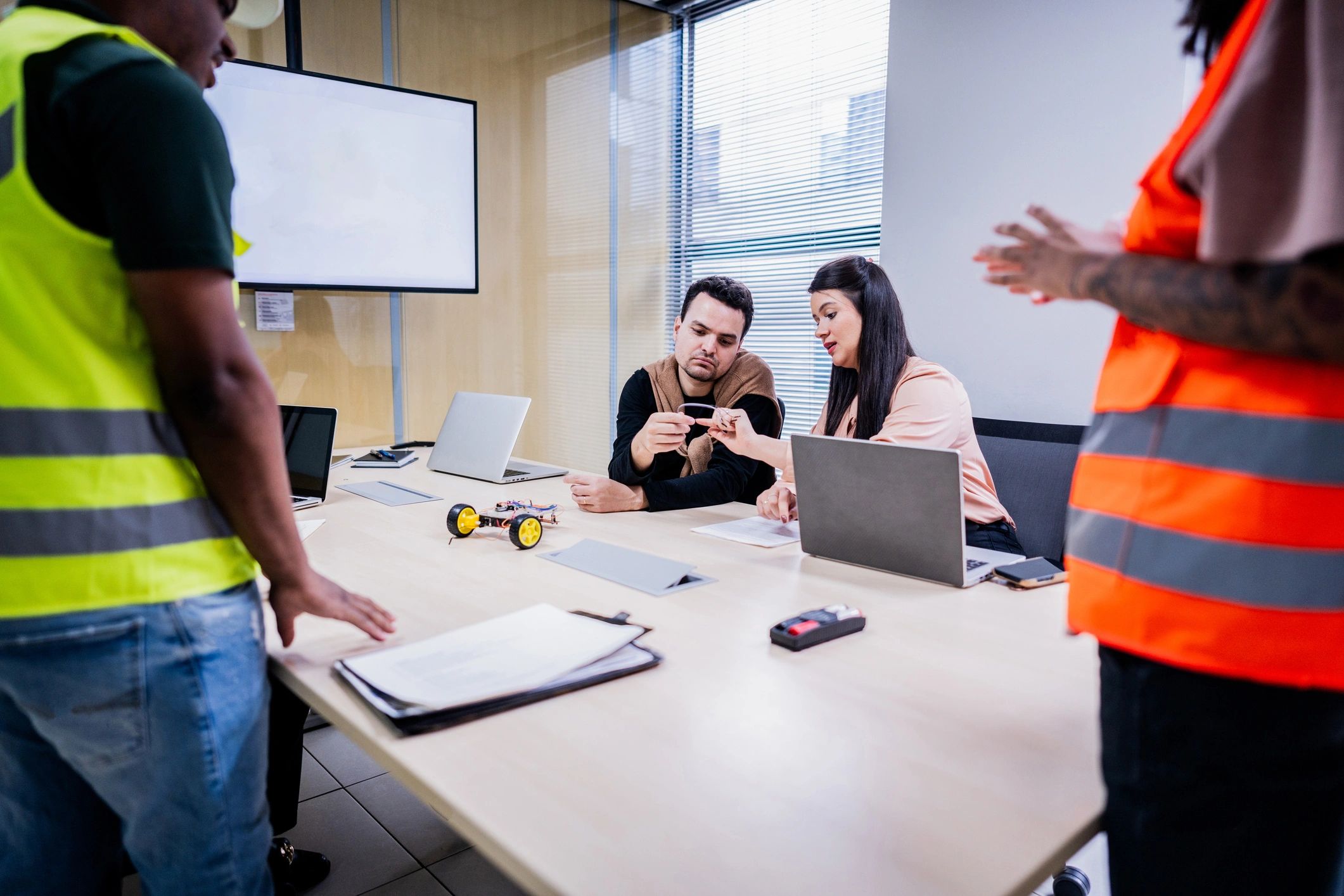 Team reviewing audiovisual equipment and plans in a meeting room